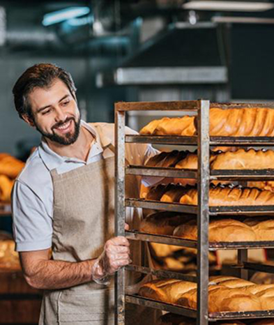 baker is smiling while preapering breads